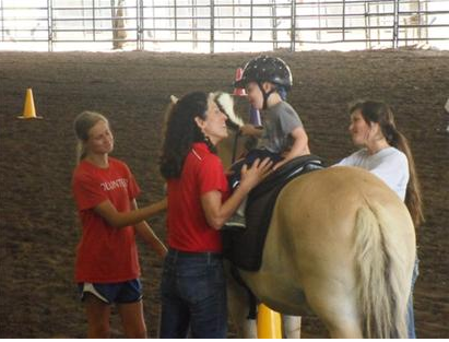 Woman talking to a child riding on a horse