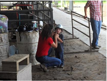 Woman puts a helmet on a child